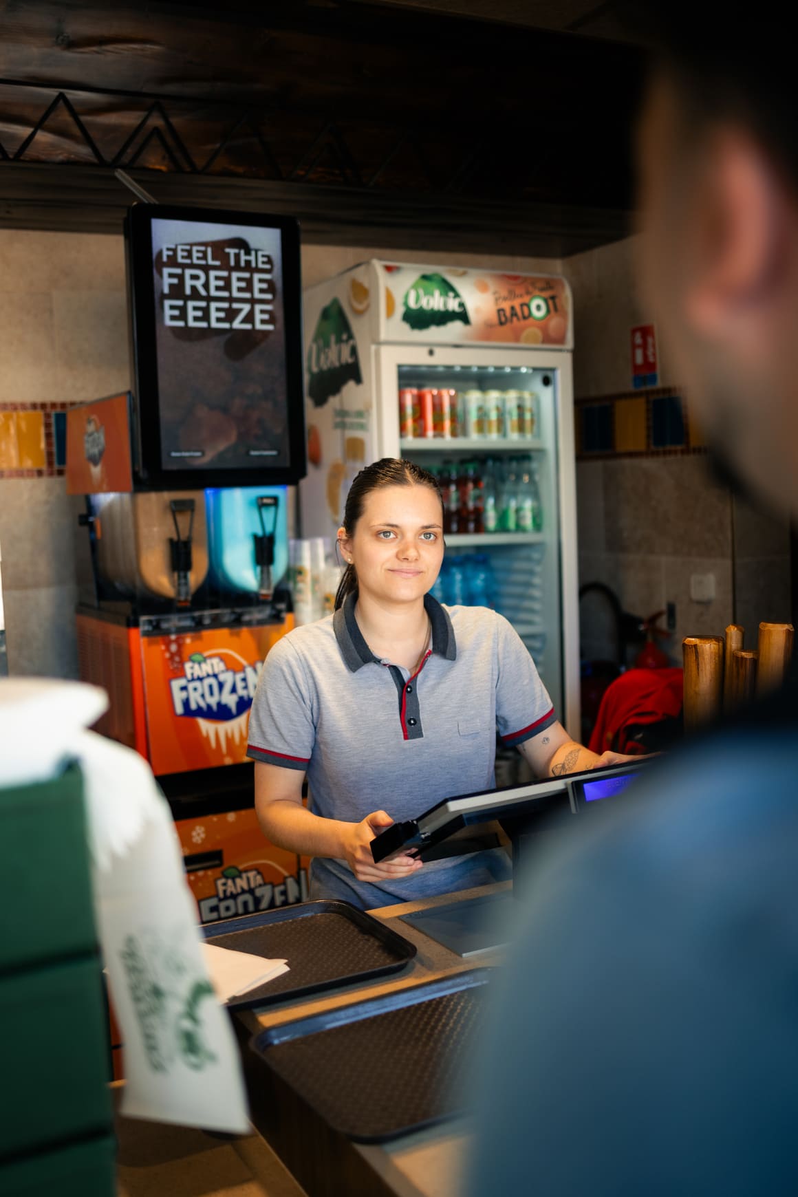 Une manager en restauration sert des clients dans un restaurant du Parc Astérix.