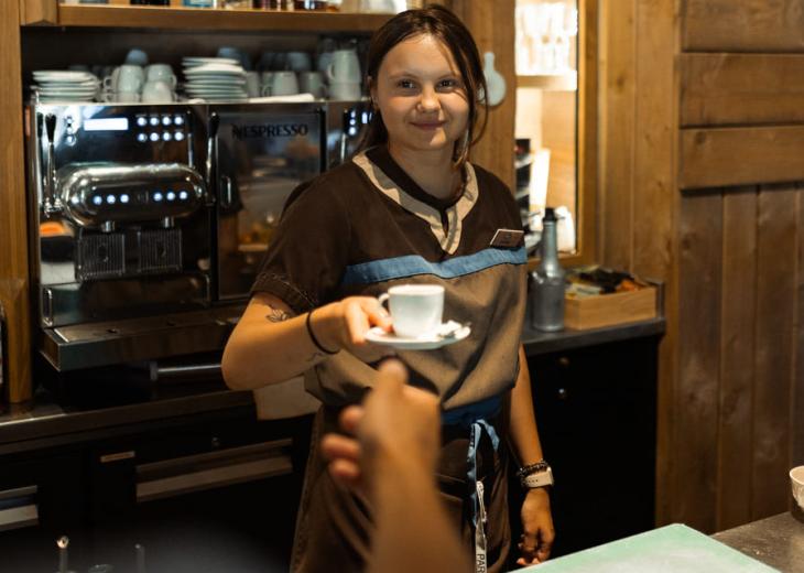 Une barmaid sert une boisson à un client dans un bar du Parc Astérix.