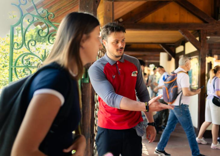 Un conseiller vendeur accueille et renseigne les visiteurs à l’entrée du Parc Astérix.