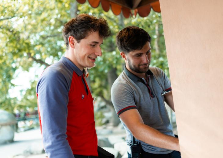 Deux conseillers vendeurs rangent les produits d’une boutique extérieure du Parc Astérix.