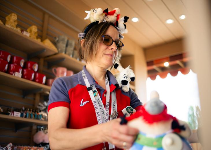 Une conseillère vendeuse range les produits dans une boutique du Parc Astérix.