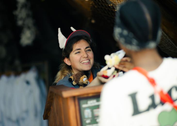 Une conseillère vendeuse accompagne une cliente dans le choix d’un produit au Parc Astérix.