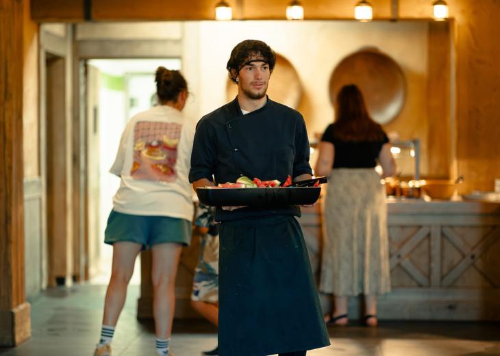 Un second de cuisine installe un plateau sur le buffet d’un hôtel du Parc Astérix.