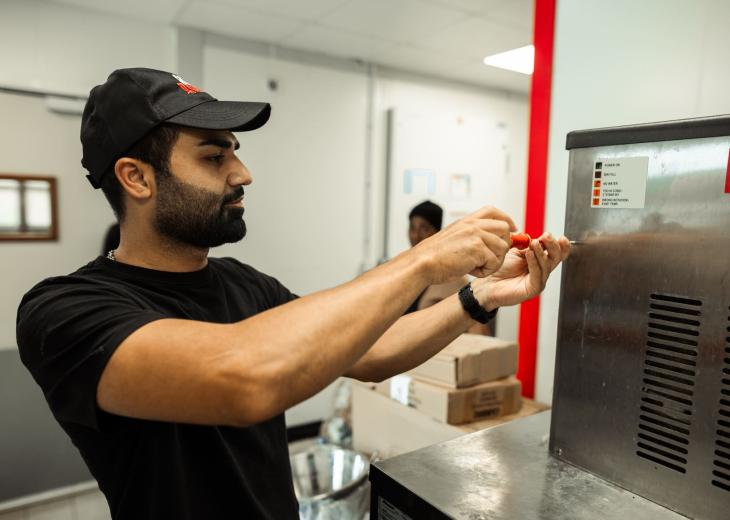 Un technicien de maintenance contrôle une machine dans un restaurant du Parc Astérix.