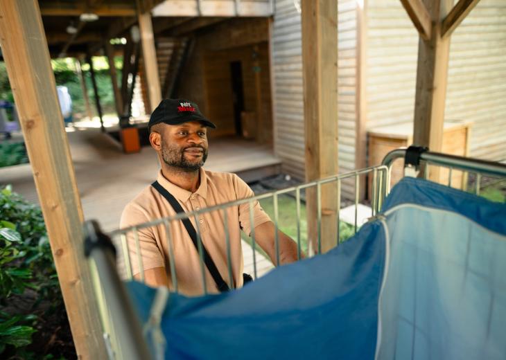 Un valet de chambre pousse un chariot de linge dans un hôtel du Parc Astérix.